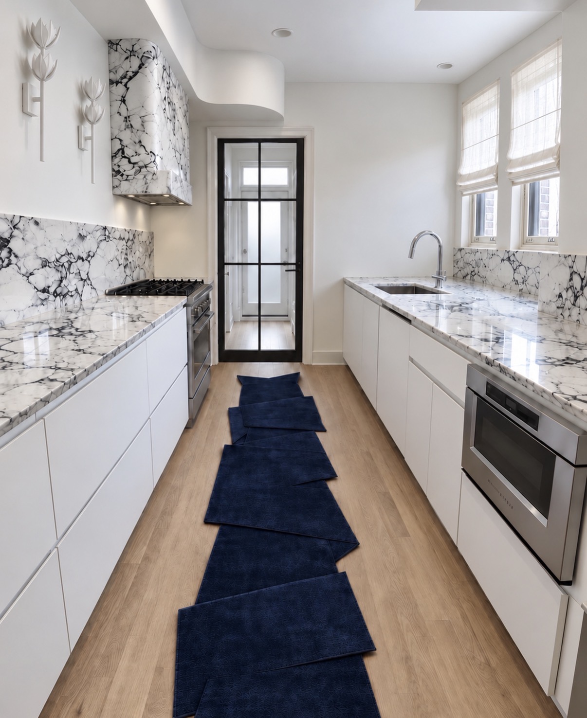 Galley kitchen with sculptural stone hood, white cabinetry and a navy runner