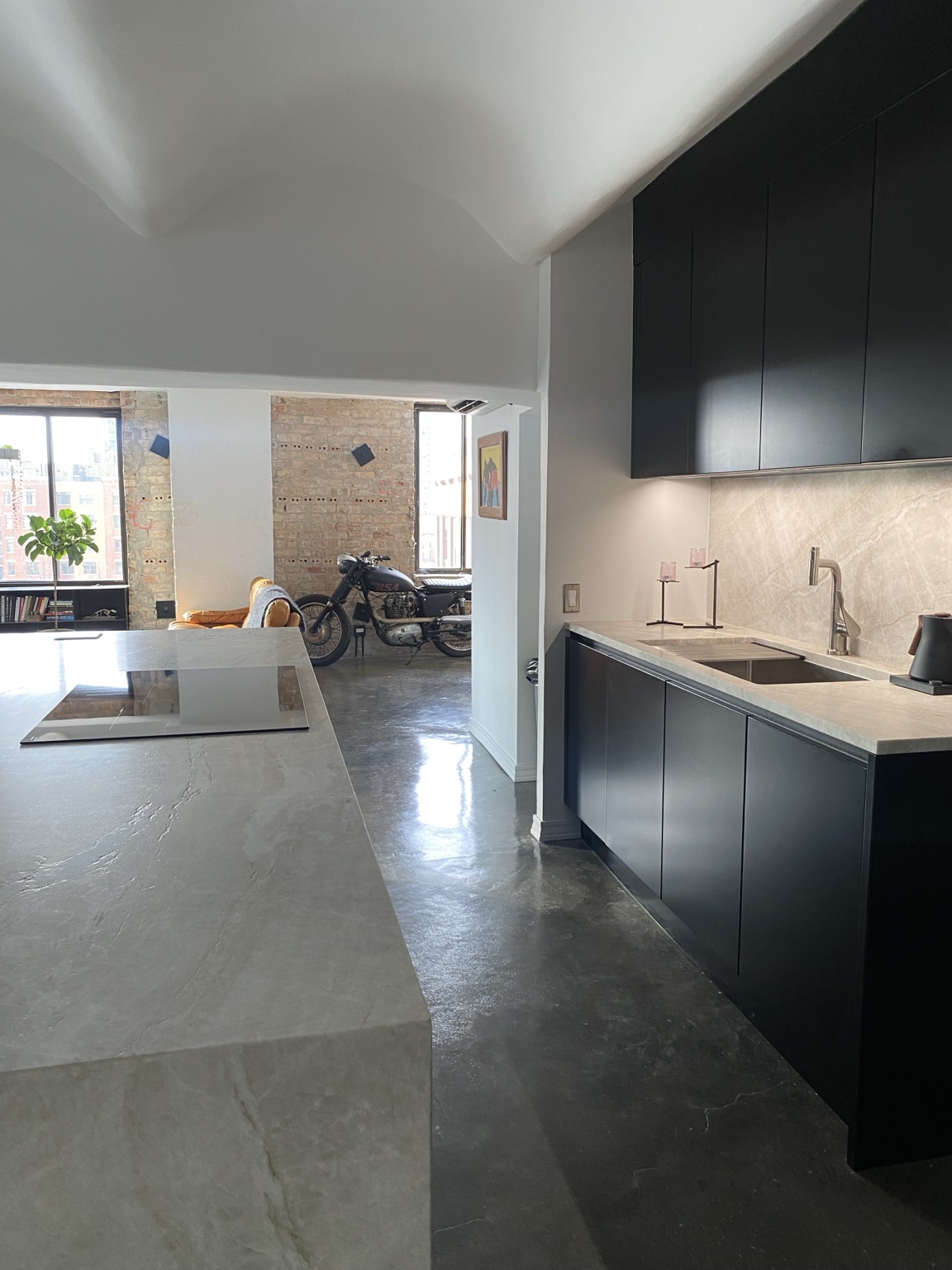 View between the island and sink showing exposed brick and the adjoining loft