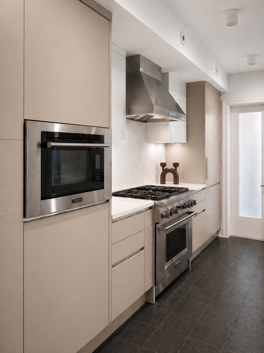 Stainless steel range and wall oven framed by neutral cabinetry